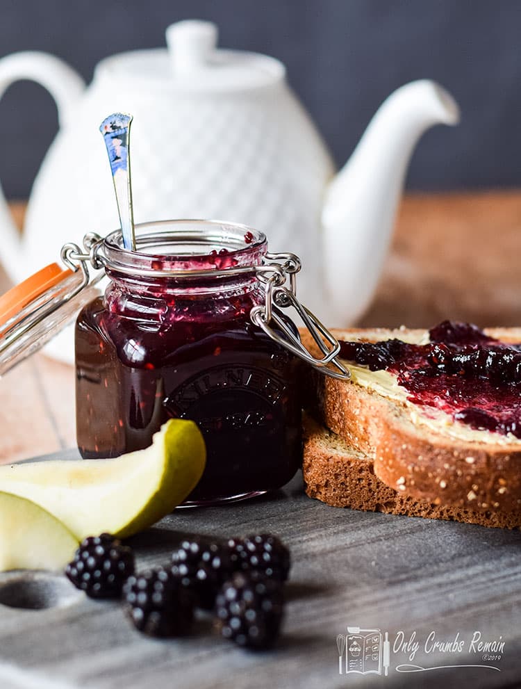 pot of blackberry and pear jam  with some spread on bread.