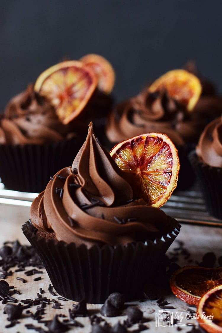 Double chocolate orange cupcake in front of rack with more